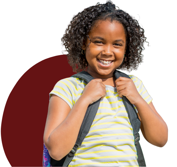 little girl with school bag smiling at camera